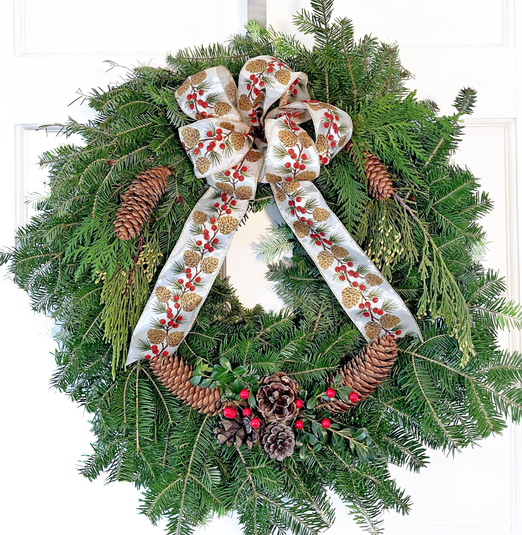 22" Wreath with Pine Cone Print Bow, decorated with greens, pine cones & berries